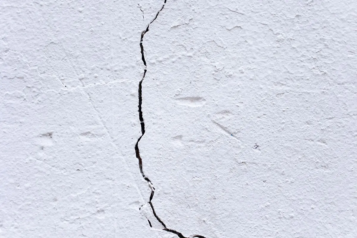 A settlement crack running down a white painted wall