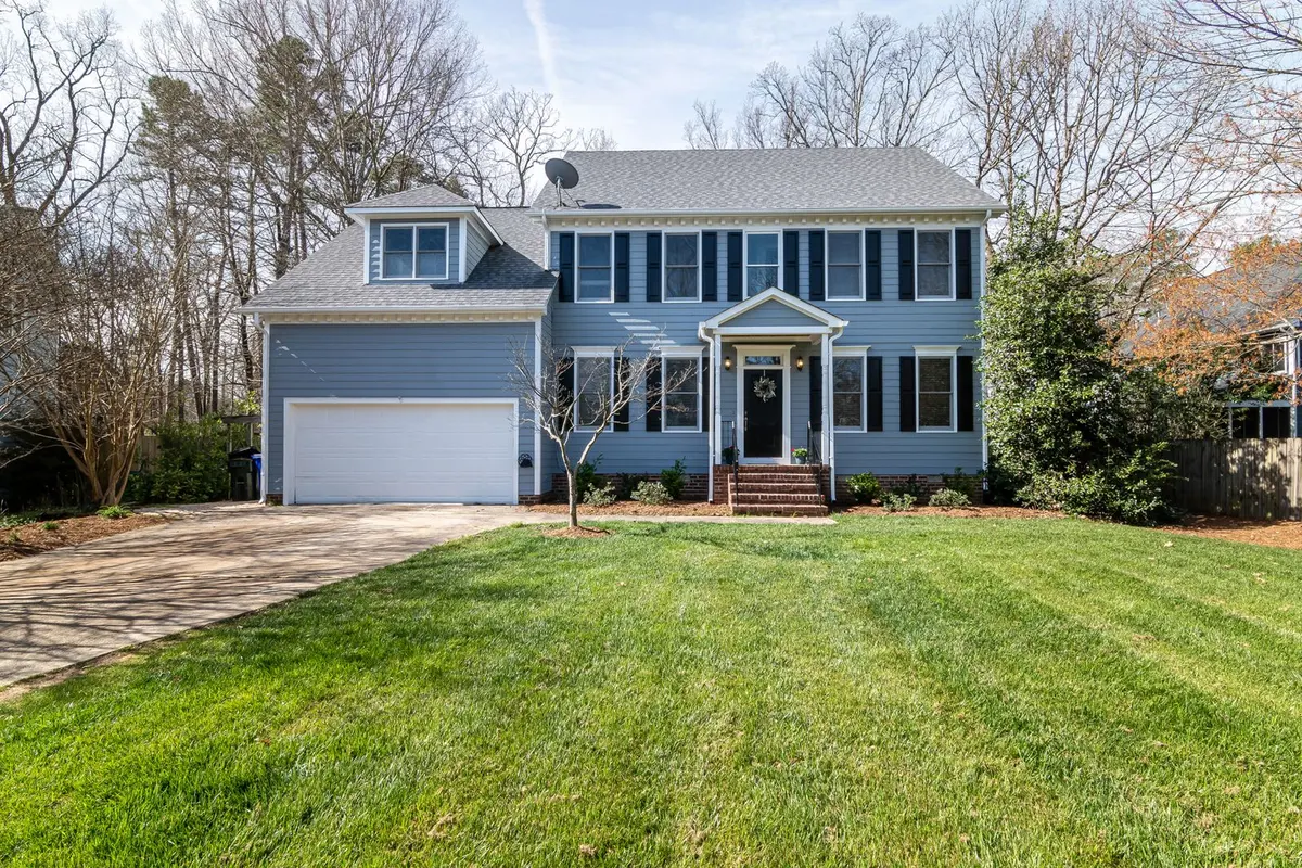 A two-story suburban home with painted siding, white trim and a wide front lawn